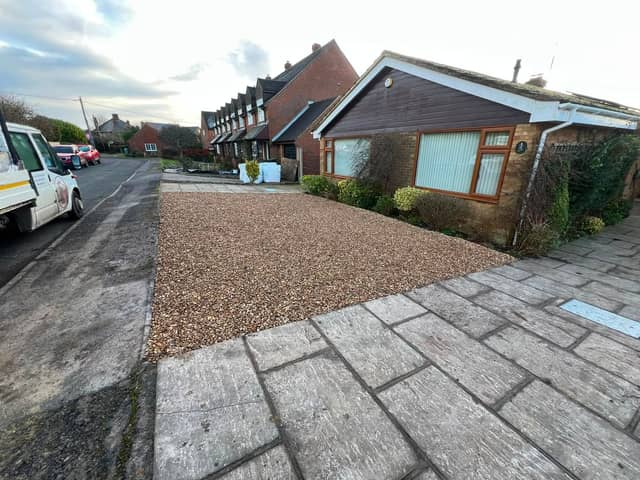 Gravel driveway and paved path to a bungalow